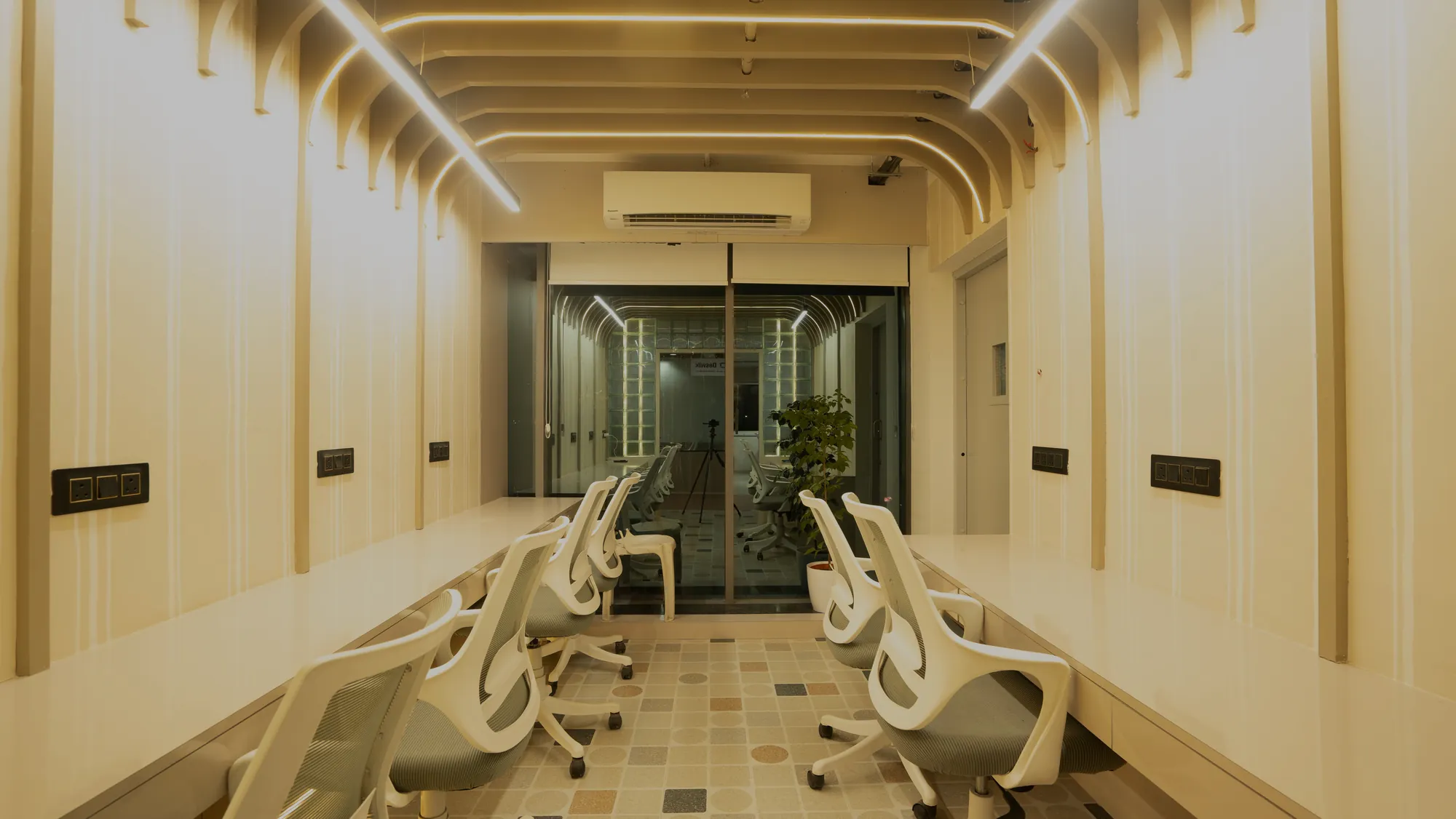 Workspace under a ribbed timber ceiling with rows of white task chairs