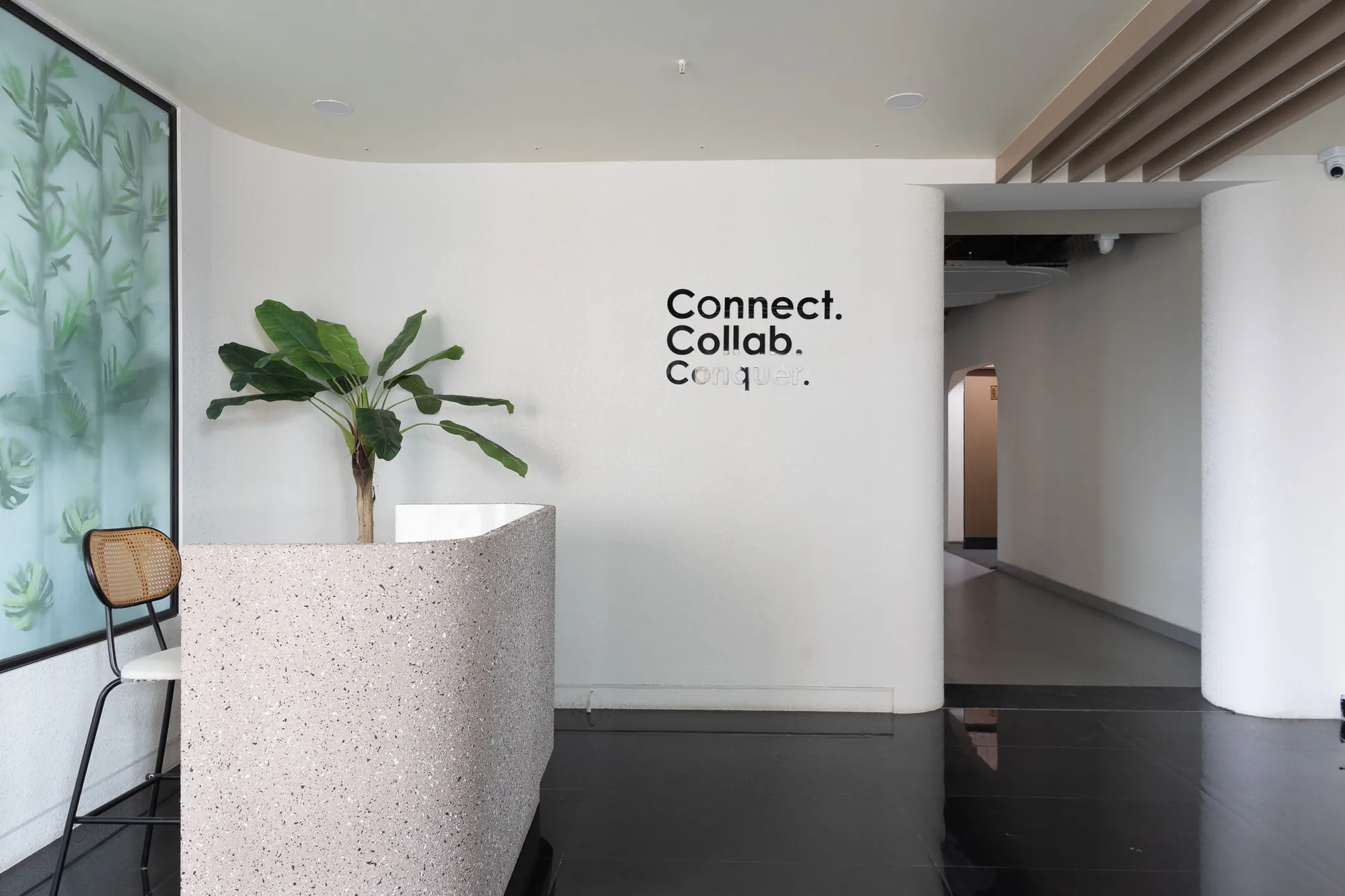 Reception with a terrazzo desk and the words Connect. Collab. on the wall