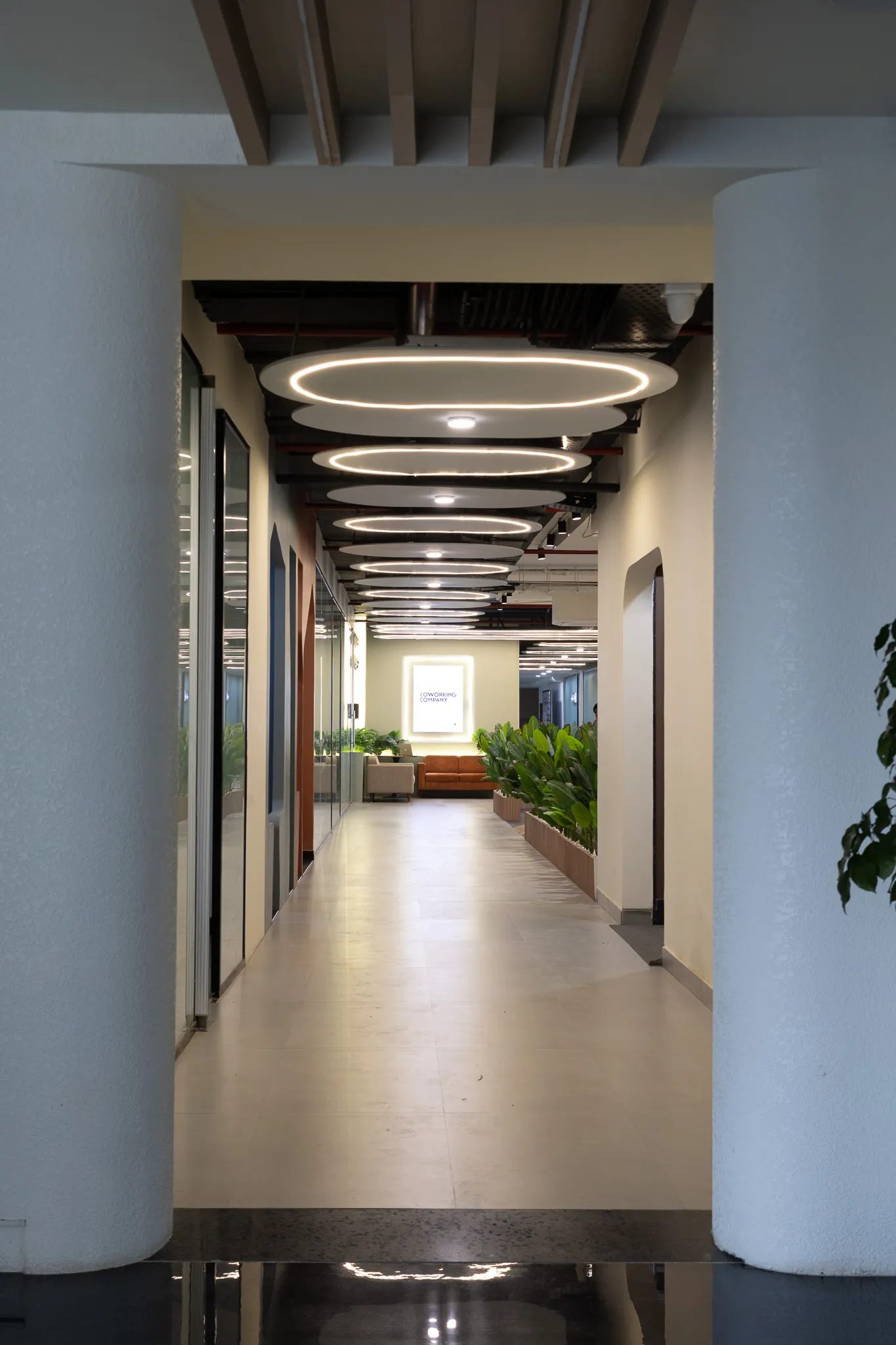 Long corridor framed by a powder-blue portal and ring lights
