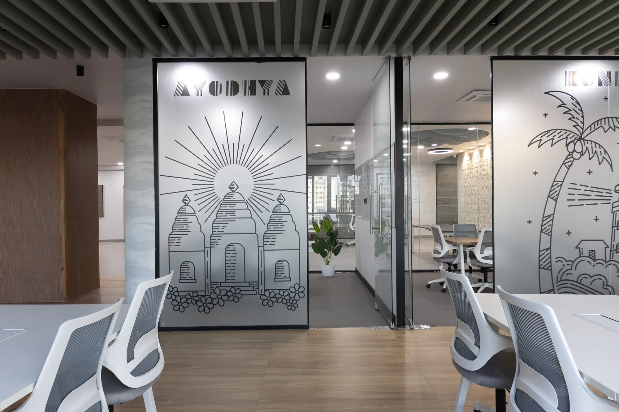 Glass cabins with etched illustrations facing an open workspace