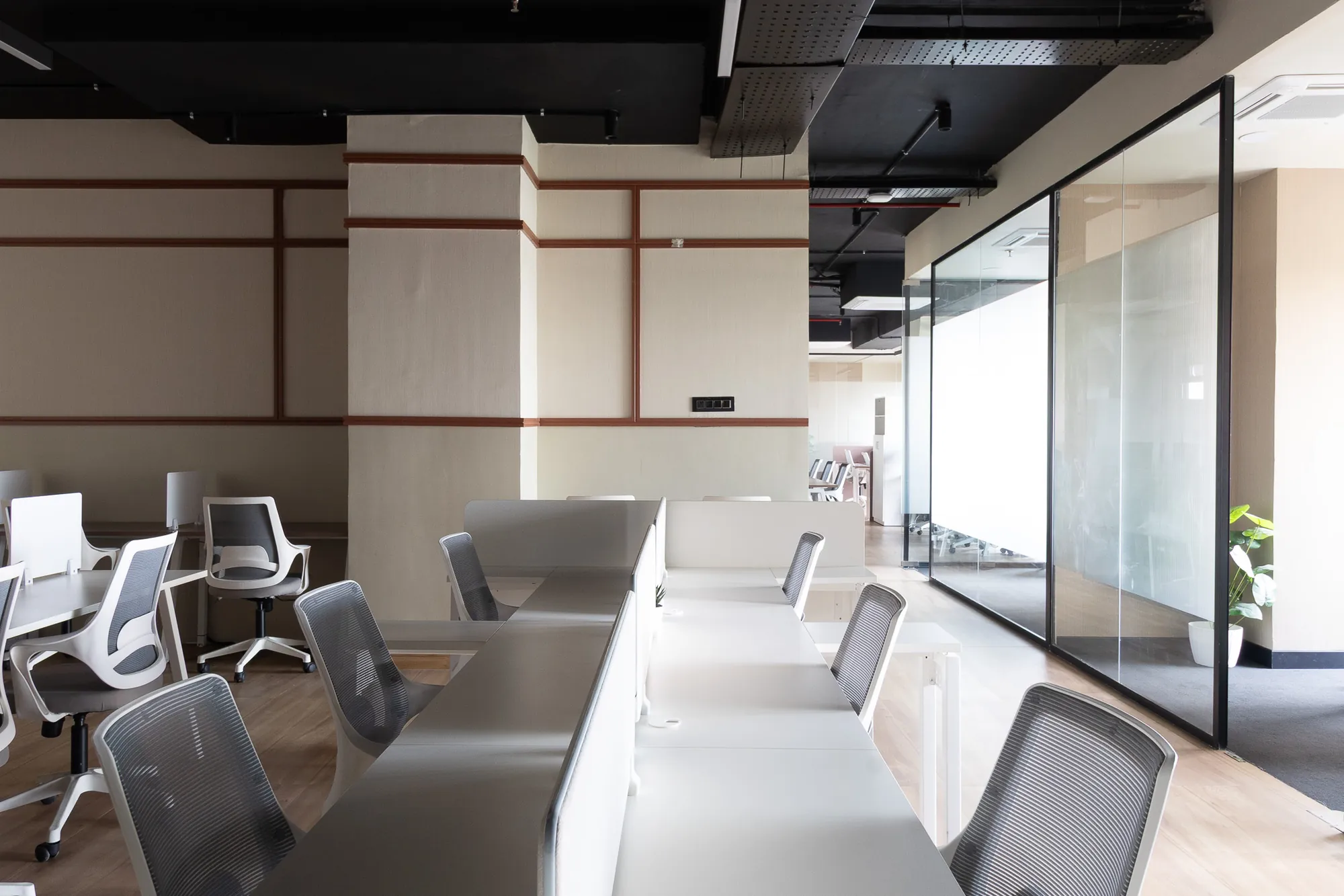 Workstations framed by timber-trimmed wall panels and a glass partition