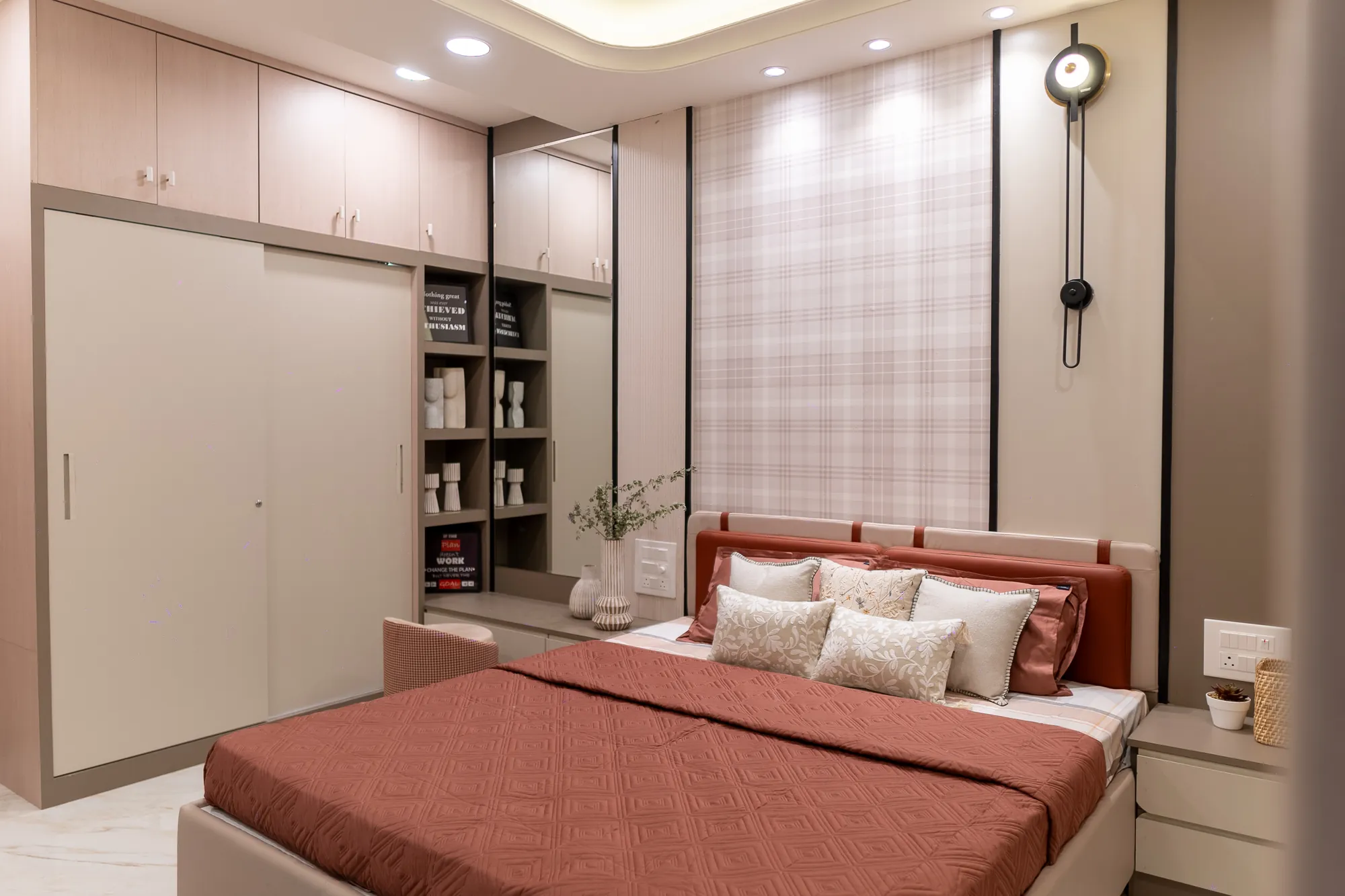 Terracotta bedroom with sliding wardrobe, open shelving and a checked feature wall
