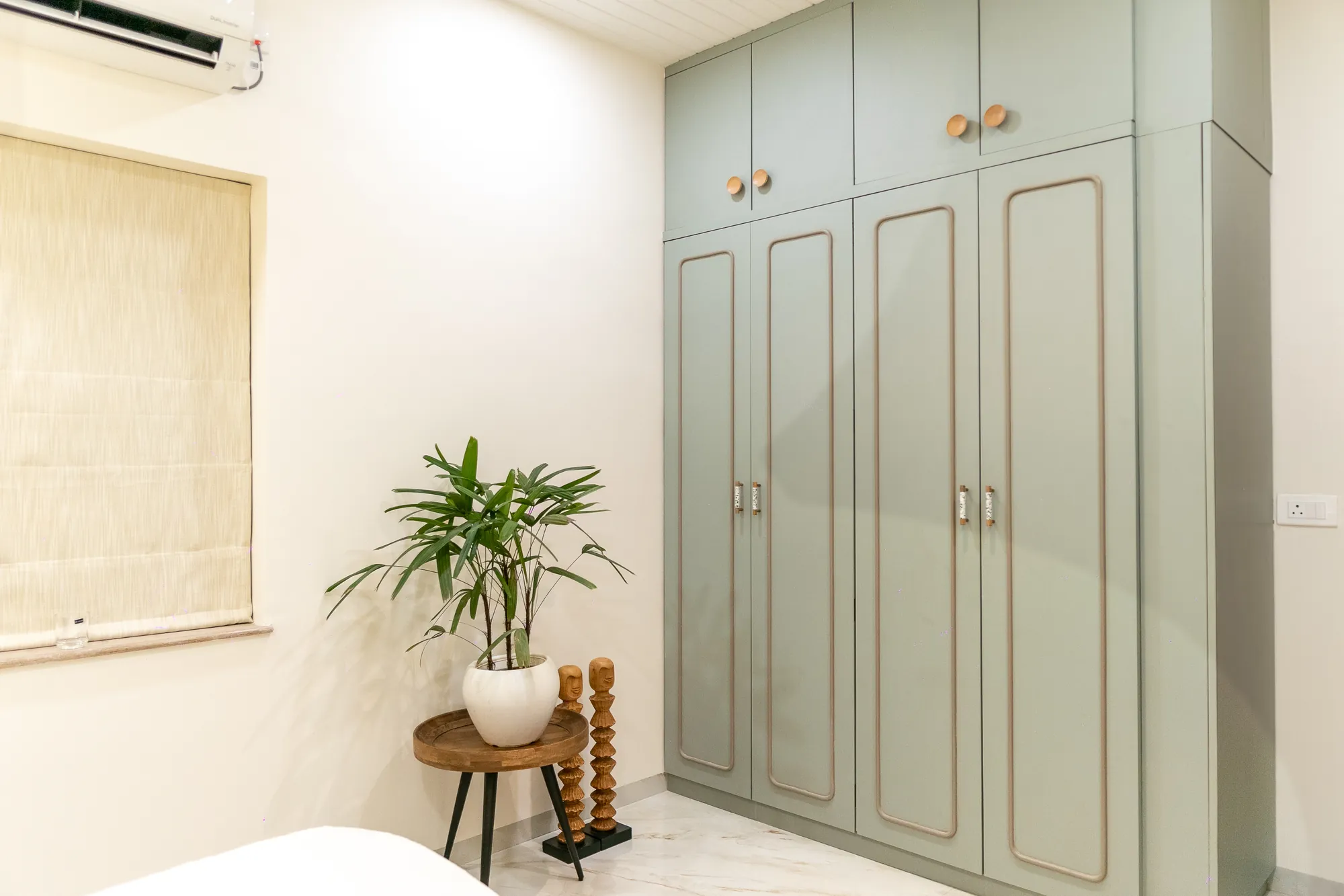 Sage-green wardrobe with rounded panel detailing