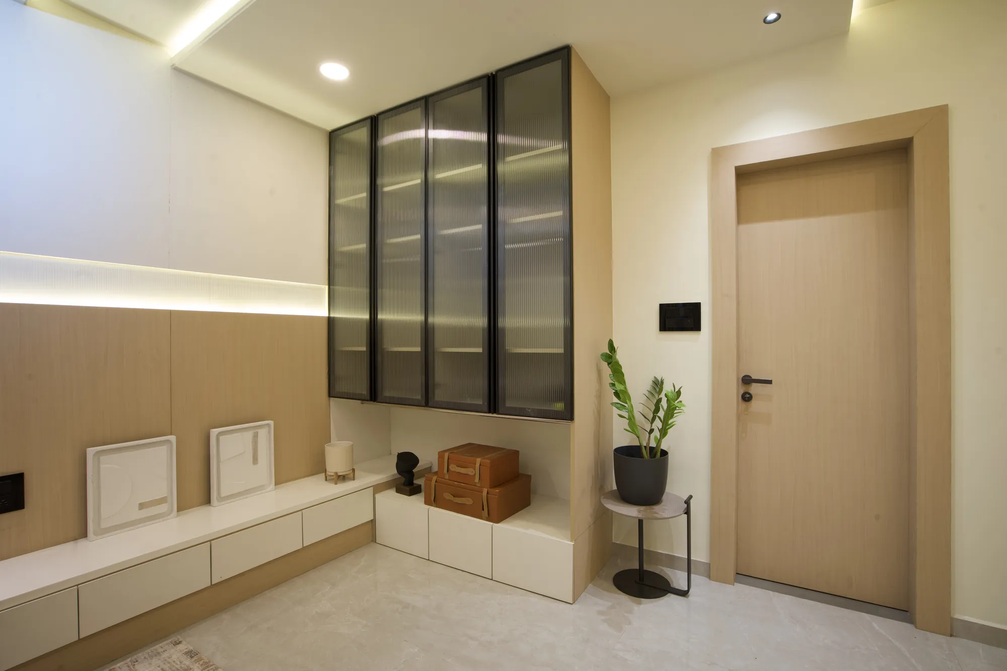 Fluted-glass cabinet above a low white storage unit