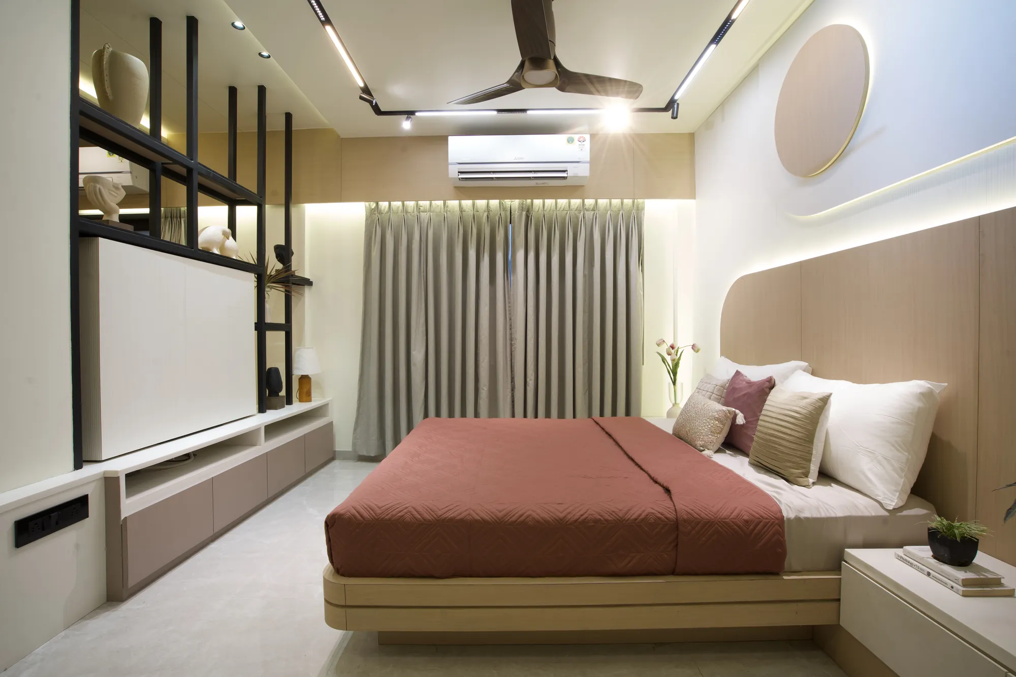 Wide view of the bedroom with the panelled headboard wall and television partition