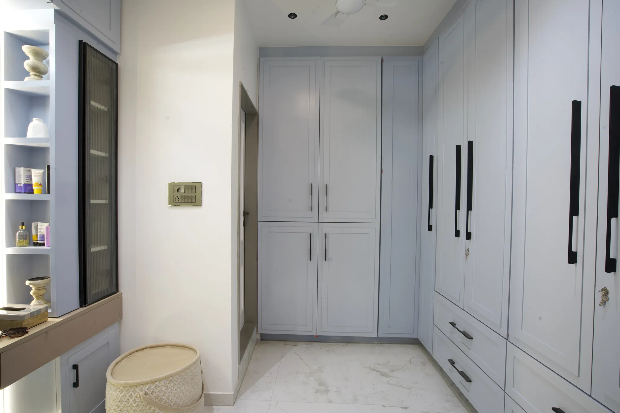 Dressing area with powder-blue wardrobes and open shelving