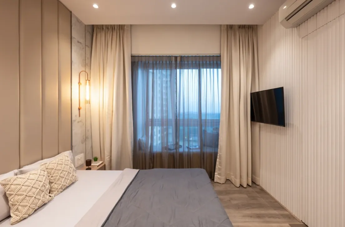 Bedroom with fluted beige panelling and full-height curtains